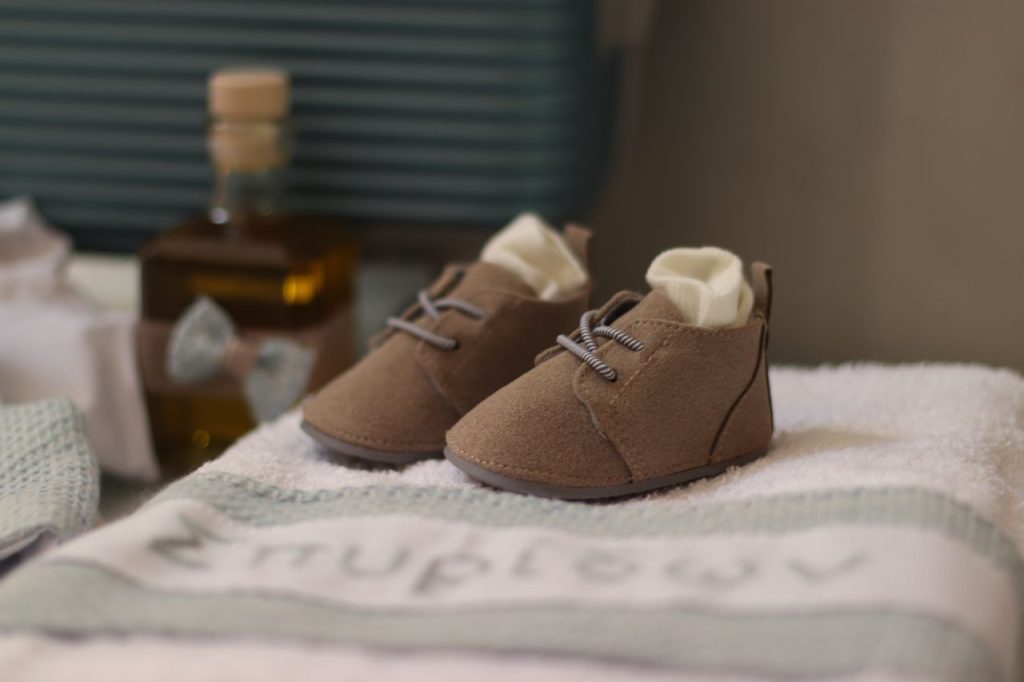 Adorable brown baby shoes resting on soft towels, perfect for a cozy, minimalist nursery.